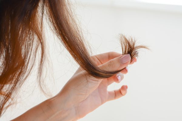 vrouw met gespleten haarpunten in hand